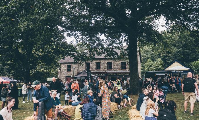 A crowd of people sitting on hay bales on Gwalia Green